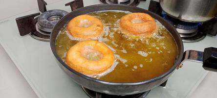 rosquillas variadas con glaseado de chocolate, glaseado rosa y rosquillas. donas en mano o bandeja foto