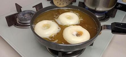 rosquillas variadas con glaseado de chocolate, glaseado rosa y rosquillas. donas en mano o bandeja foto