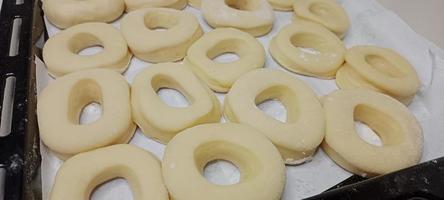 assorted donuts with chocolate frosted, pink glazed and sprinkles donuts. Donuts in hand or tray photo