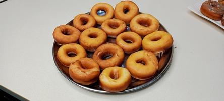 assorted donuts with chocolate frosted, pink glazed and sprinkles donuts. Donuts in hand or tray photo