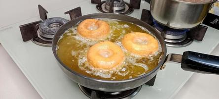 rosquillas variadas con glaseado de chocolate, glaseado rosa y rosquillas. donas en mano o bandeja foto