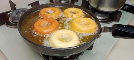 assorted donuts with chocolate frosted, pink glazed and sprinkles donuts. Donuts in hand or tray photo