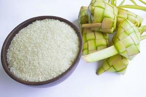 ketupat in earthenware plate isolated on white background. Ketupat ,Rice Dumpling is food served when idhul fitri eid mubarak in Indonesia, made from rice wrapped in young coconut leaves, janur photo