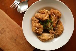 Delicious homemade crispy fried chicken with spicy taste and lemon on plate photo