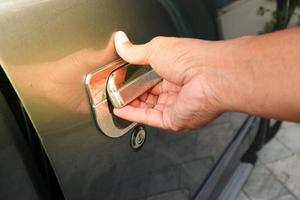 Hand man on handle. Close-up of man in opening a car door photo