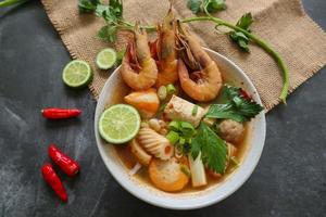 Tom yam soup originating from Thailand. Tom yum is made with shrimp, chili, lime, chicken, fish, or seafood and mushrooms. photo