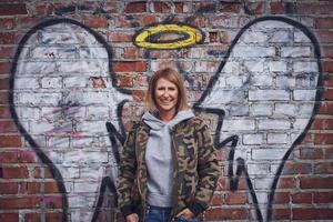 Young adult woman with angel wing on the wall photo