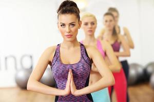 grupo de mujeres haciendo yoga en el gimnasio foto