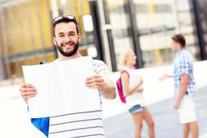 Young student standing in the campus with an open notebook photo