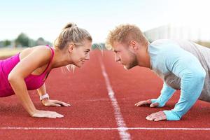 Man and woman racing on outdoor track photo