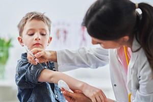 Little boy being vaccinated by pediatrician photo