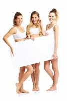 grupo de amigos felices posando en ropa interior con pancarta foto