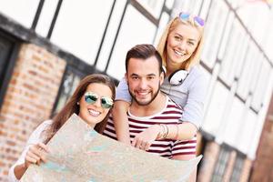 Group of happy friends sightseeing with map photo