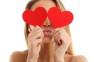 Beautiful woman covering eyes with hearts photo