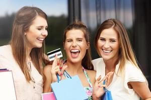 Group of girlfriends shopping in the city with credit card photo