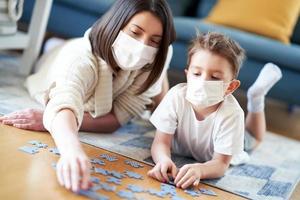 Mother and child playing together at home isolation duringcoronavirus pandemic photo