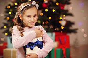 Happy girl posing with presents during Christmas time photo