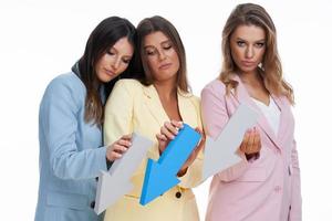 Three women in pastel suits posing with arrows over white background photo