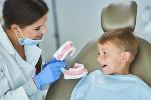 niño pequeño y mujer dentista en la oficina de dentistas foto