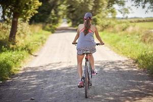 Young happy woman on a bike in countryside photo
