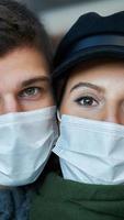 Happy couple celebrating Valentines Day in masks during covid-19 pandemic photo