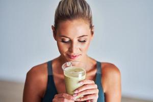 Adult woman drinking healthy smoothie after workout photo