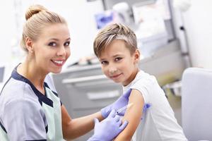 Brave little boy receiving injection or vaccine with a smile photo