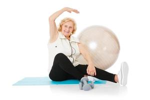 mujer mayor haciendo ejercicio de estiramiento en la alfombra foto