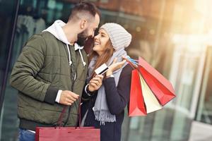 retrato de pareja feliz con bolsas de compras después de ir de compras en la ciudad foto