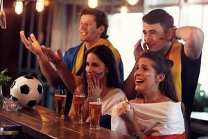 Group of friends watching soccer in pub photo