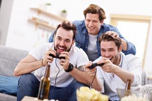 Friends having fun on the couch with video games photo