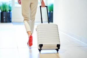 Businesswoman with luggage in modern hotel lobby photo