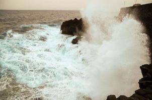 fuertes olas golpeando las rocas foto