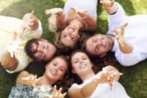 grupo de amigos divirtiéndose juntos en el césped foto