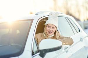Happy woman driving car in snowy winter photo