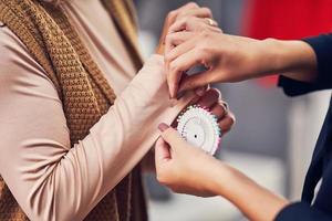 Fashion designer assisting the customer in clothes boutique photo