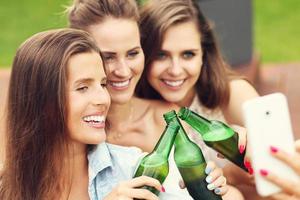 Happy group of friends drinking beer outdoors photo