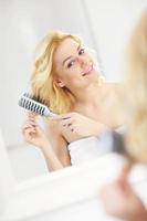 Young woman brushing hair photo