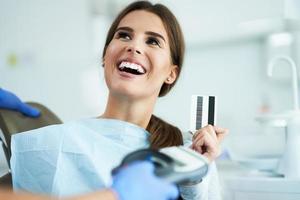 Adult woman paying for visit in dentist office photo