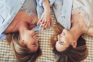 Two young girlfriends on the bed photo