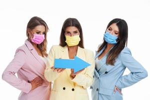 Three women in pastel suits posing with arrows over white background photo