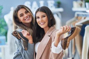 Two happy girls on shopping holding shoes photo