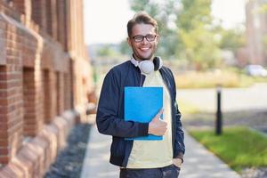 Male student in the campus studying outdoors photo