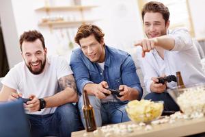 Friends having fun on the couch with video games photo