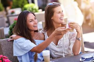 Happy girl friends in cafe during summer time photo