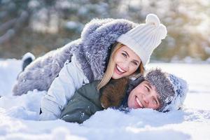 pareja divirtiéndose en el paisaje invernal y la nieve foto