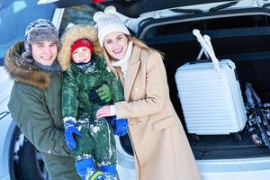 familia joven durante el maletero del coche de viaje de invierno en bacground foto