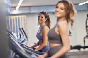 Two girl friends working out on treadmill photo