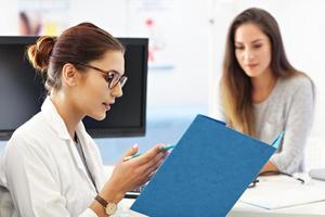 Adult woman having a visit at female doctor's office photo