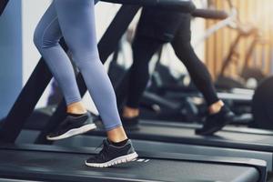 Legs of two girl friends working out on treadmill photo